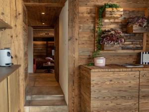 a kitchen with wood paneling and a hallway at Nido sull`Aqua Chalet with Whirlpool in Sigriswil