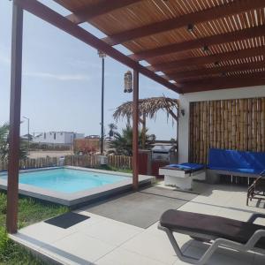 a patio with a swimming pool and a wooden pergola at Casa Chincha in San Pablo