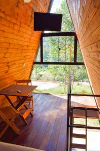 a wooden room with a wooden table and a large window at Be Happy Park Piracaia in Piracaia