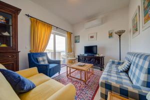 a living room with a couch and chairs and a tv at Davina House - Terrace & Garden - Sea Views in St. Paul's Bay