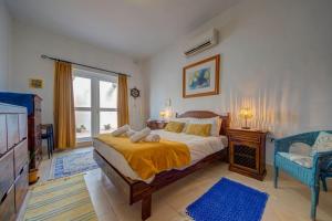 a bedroom with a bed and a tv and a window at Davina House - Terrace & Garden - Sea Views in St. Paul's Bay