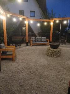 a pavilion with a couch and chairs and lights at Na Brzysku in Jabłonka