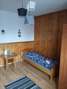 a small bedroom with a bed and a table at Na Brzysku in Jabłonka +14 photos