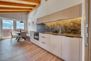 a kitchen with white cabinets and a dining table at Garni Schmiedhof in Naturno