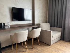 a living room with a television and two chairs at Amaro Hotel Uman in Uman