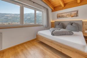 a bedroom with a large white bed with windows at Garni Schmiedhof in Naturno +22 photos
