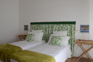 a bedroom with two beds with green and white pillows at Theia Apartment in Chianciano Terme