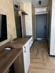 a kitchen with a counter and a tv in a room at Amaro Hotel Uman in Uman