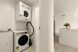 a laundry room with a washing machine and a microwave at 2BDR Luxury Apartment Panoramic Views in Gosford