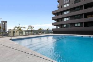 a large blue swimming pool next to a building at 2BDR Luxury Apartment Panoramic Views in Gosford