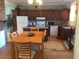 a kitchen with a wooden table and a table and chairs at Downtown Apt 5 Private Deck Queens Road in St. John's