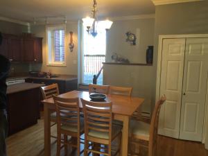 a kitchen with a wooden dining room table and chairs at Downtown Apt 5 Private Deck Queens Road in St. John's +14 photos