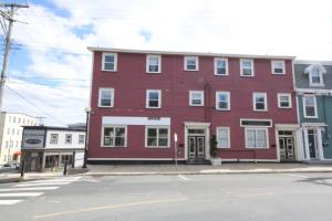 a red building on the corner of a street at Downtown Apt 5 Private Deck Queens Road in St. John's