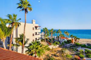 an aerial view of a resort with palm trees and the ocean at Elegant Beachfront Penthouse | Casa Del Mar Delfin in San José del Cabo