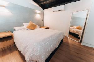 a small bedroom with a bed and a mirror at Daybreak Loft. Willunga in Willunga