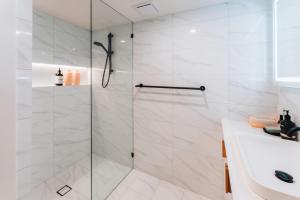 a white bathroom with a shower and a sink at Daybreak Loft. Willunga in Willunga +12 photos