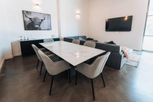 a dining room with a table and chairs and a couch at Daybreak Loft. Willunga in Willunga