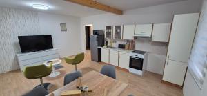 a kitchen with white cabinets and a table and chairs at Apartmány U BERANA in Česká Lípa