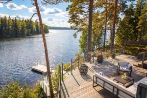 a wooden deck with chairs and a view of a lake at Stay North - Kajastus in Salo