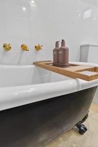 a bathtub with two bottles on top of it at Forty at Yellow Doors in Goolwa South +8 photos