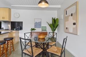 a dining room with a glass table and chairs at Forty at Yellow Doors in Goolwa South