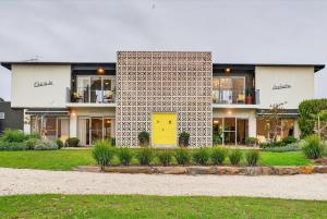 a building with a yellow door in a yard at Forty at Yellow Doors in Goolwa South