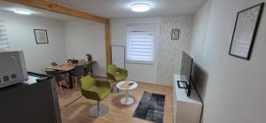 a living room with a table and green chairs at Apartmány U BERANA in Česká Lípa