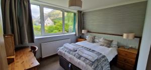 a bedroom with a bed and a large window at Hawthorn in Glencoe