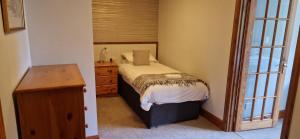 a small bedroom with a bed and a dresser at Hawthorn in Glencoe