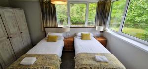 two beds in a room with two windows at Hawthorn in Glencoe +13 photos