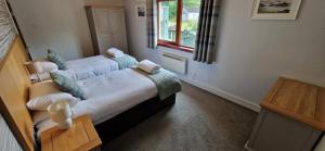a bedroom with a large bed with a window at Holly Tree Cottage in Glencoe