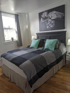 a bedroom with a large bed with green and gray pillows at Downtown Apt 2 executive 21 Queens Road in St. John's