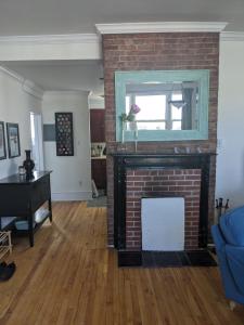 a living room with a brick fireplace with a mirror at Downtown Apt 2 executive 21 Queens Road in St. John's