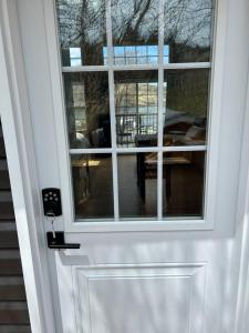 a white door with a window and a table at Cupids Guest House and SheShed in Brigus
