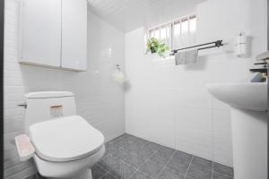 a white bathroom with a toilet and a sink at Yoonsul Gwangalli 3beds for 4guests in Suyŏng