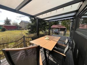 awning over a deck with a table and chairs at Tiny House Spreemaus in Hangelsberg