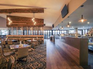 a restaurant with tables and chairs and a bar at Mercure Warragul in Warragul