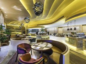 a restaurant with a yellow ceiling and tables and chairs at NOVOTEL Jinji Lake Suzhou SIP in Suzhou