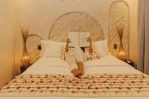 a bedroom with two beds with someone reading a book at Pousada Topázio by Amana in Fernando de Noronha