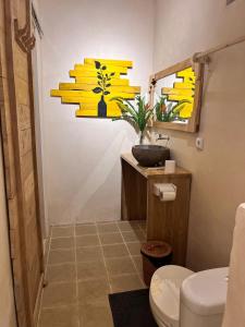 a bathroom with a toilet and a potted plant at Daumi House in Masbagik +36 photos