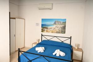 a bedroom with a blue bed with towels on it at Residence Lion in San Vito lo Capo