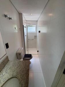 a bathroom with a shower and a toilet and a sink at Travessa 12 - Suítes centro de Serra Negra - SP in Serra Negra