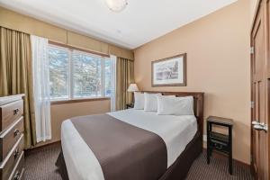 a hotel room with a bed and a window at Canmore Rocky Mountain Inn in Canmore +38 photos