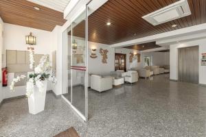 eine Lobby mit weißen Möbeln und einer Blumenvase in der Unterkunft Hotel Comendador in Bombarral