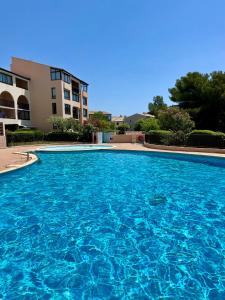 a large blue swimming pool in front of a building at TOUT A PIED Dernier étage Vue imprenable EST-SUD OUEST mer -plage 100m-box in Six-Fours-les-Plages