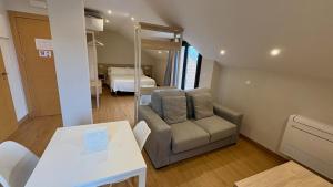 a living room with a chair and a mirror at Apartamentos La Canal in Soto de la Marina