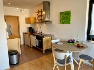 a kitchen with a wooden table and a table and chairs at Ferienwohnung Stengel in Schotten +14 photos