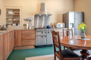 a kitchen with a table and a stainless steel refrigerator at Mackenzie House in Kirkcudbright