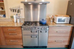 a kitchen with a stove and a microwave at Mackenzie House in Kirkcudbright