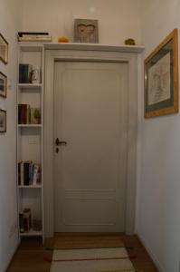 een witte deur in een kamer met een boekenplank bij Theia Apartment in Chianciano Terme